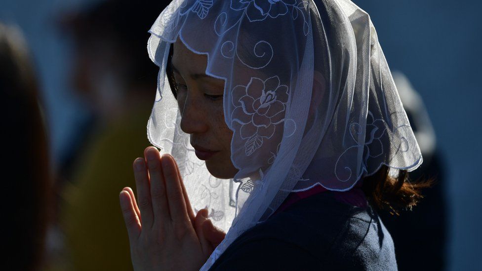 A woman attends a Holy Mass by Pope Francis at a baseball stadium in Nagasaki
