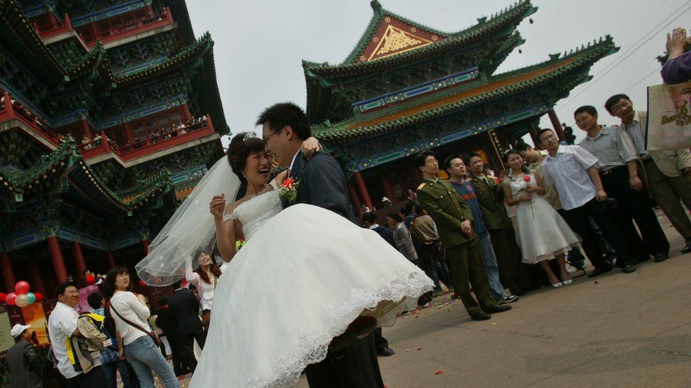 A Chinese groom lifts up his bride