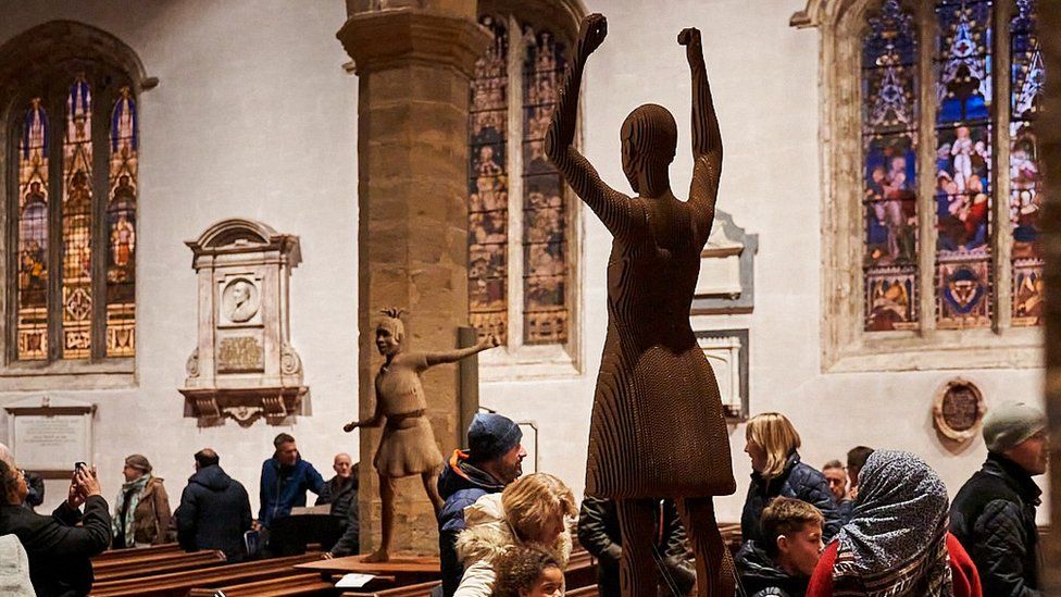 Visitors in church look at the Sophia sculptures