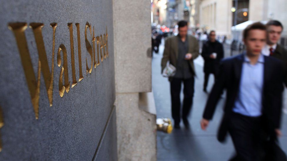 People walk along Wall Street in the financial district on April 19, 2010 in New York City.