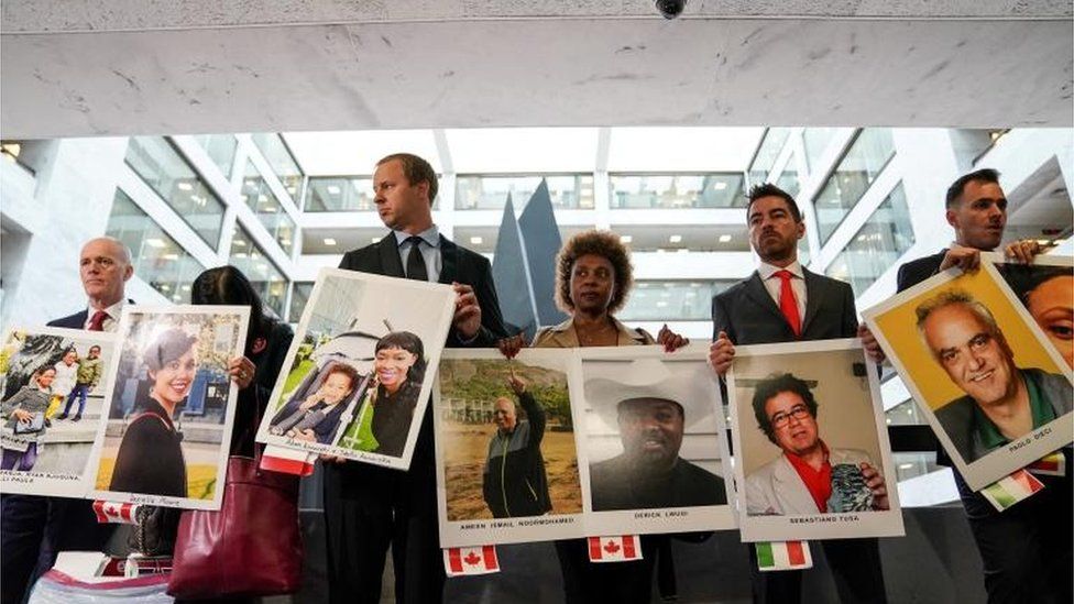 Family members hold photographs of Boeing 737 MAX crash victims lost in two deadly 737 MAX crashes
