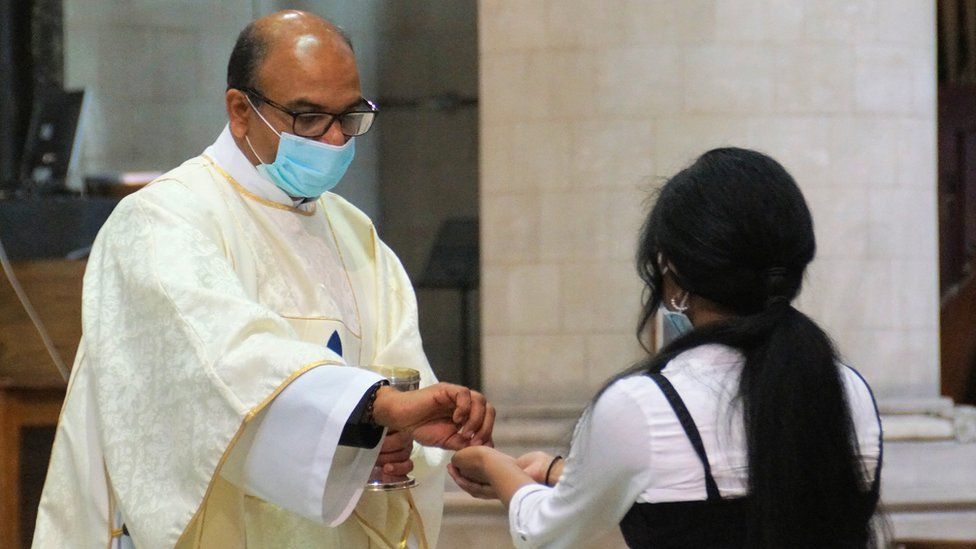 A priest giving Holy Communion