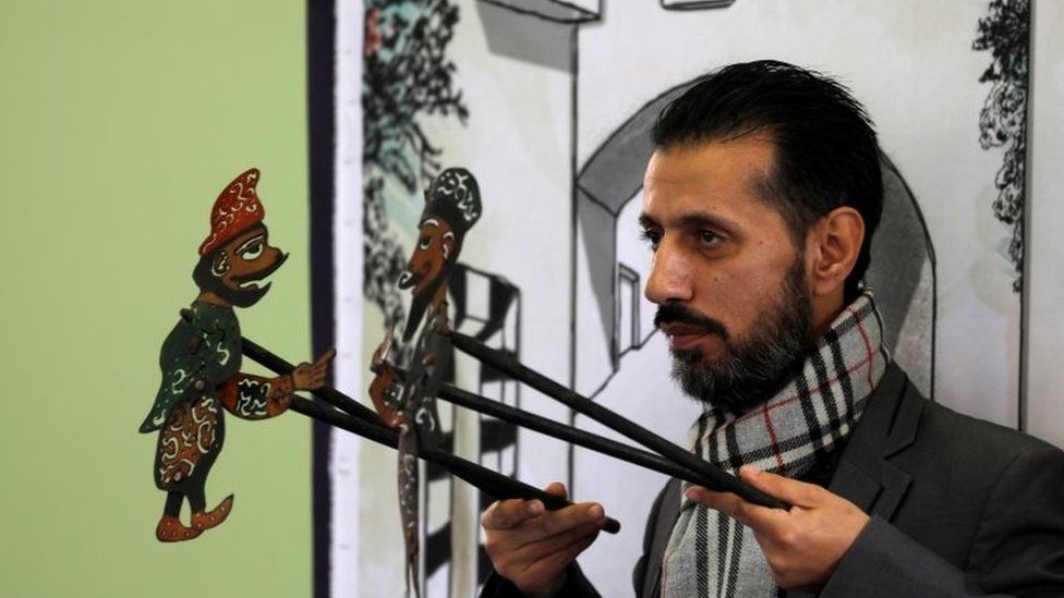 Shadi al-Hallaq, a puppeteer, holds two puppets during a performance in Damascus, Syria on 3 December 2018.