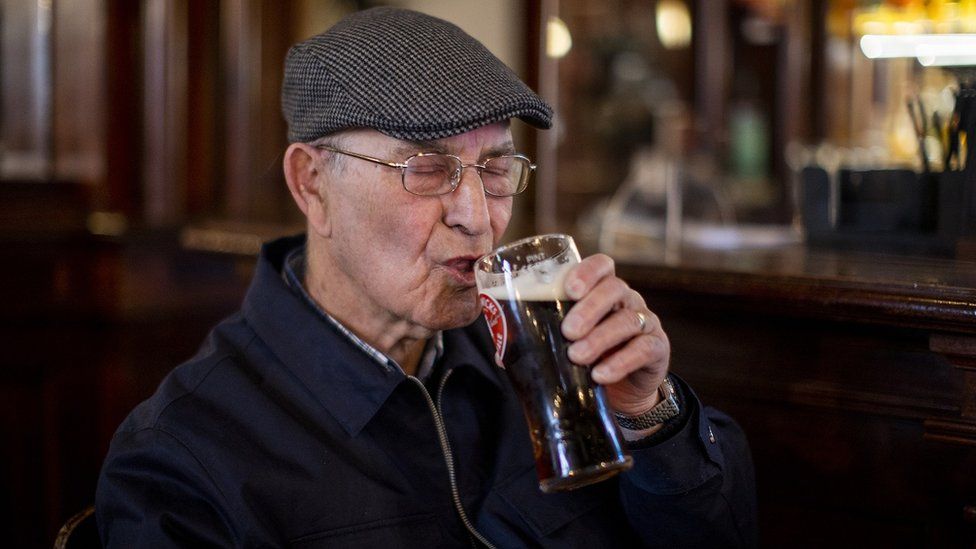 Tommy Brady, 78, enjoying his first pint since Christmas Eve at The Garrick Bar in Belfast