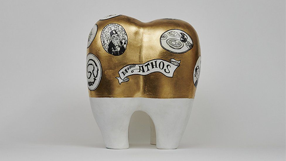 The gold plated tooth represents the kindness of a dentist monk