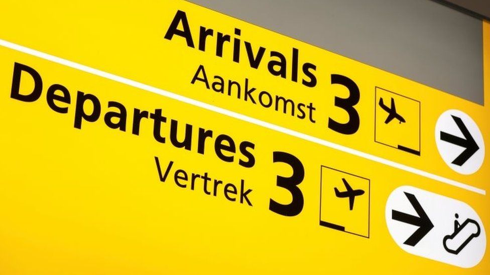 Arrivals and departures board in English and Dutch at Schiphol airport in Amsterdam. Photo: November 2021