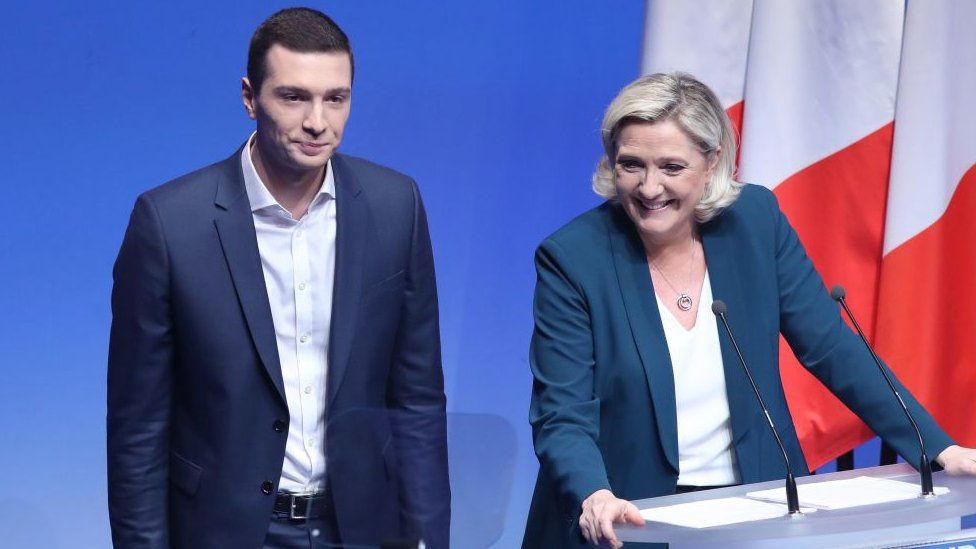 Marine Le Pen (R) smiles flanked by Jordan Bardella on January 13, 2019