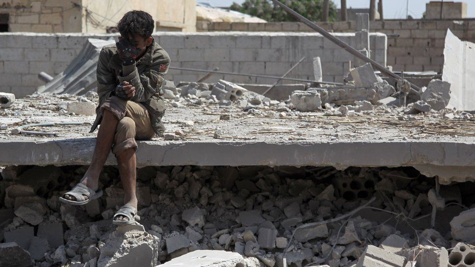 A Syrian man sits amid the rubble of a building destroyed in a reported government air strike in Saraqeb, Idlib province (7 May 2019)