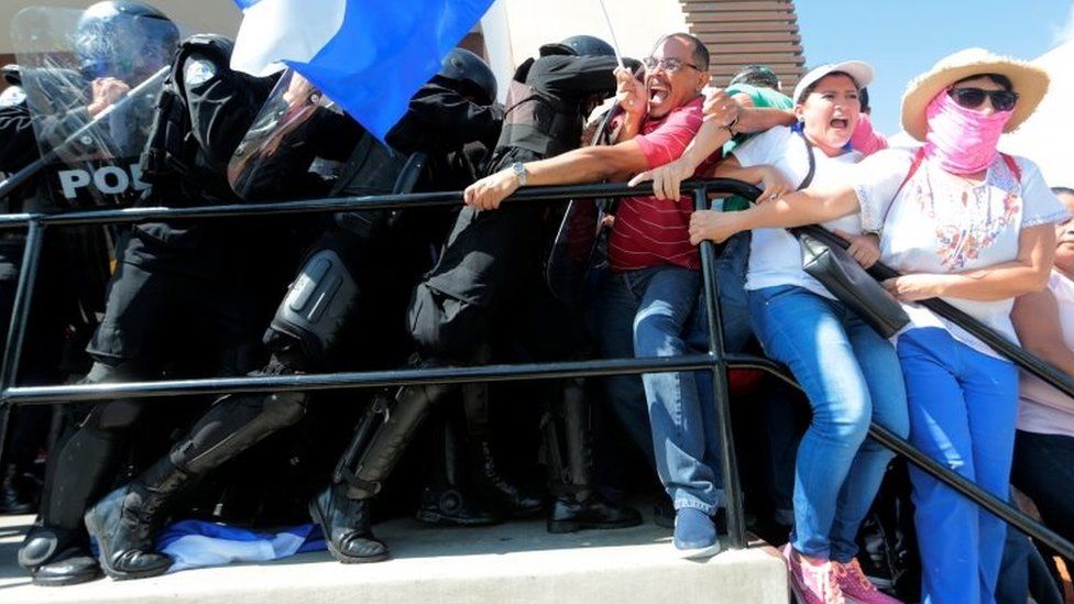 Riot police try to detain protesters during a march against Nicaraguan President Daniel Ortega in Managua
