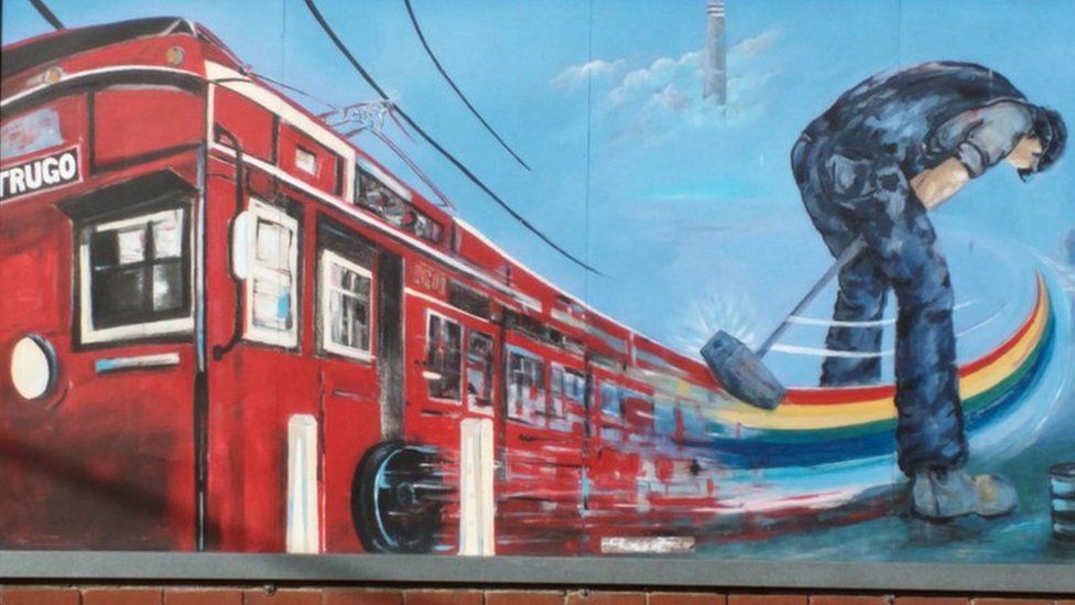 A public mural by artist Peter McMahon in Melbourne shows a person playing trugo next to a train carriage