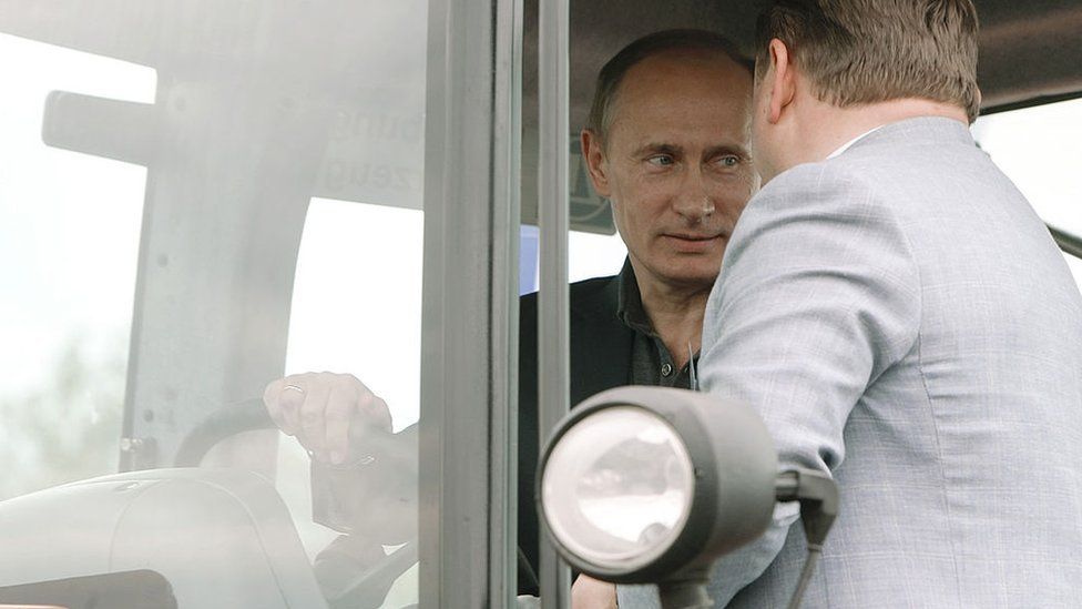 Russia's Prime Minister Vladimir Putin (L) sits in the cabin of a tractor during his visit to the city of Tambov, some 480 km (298 miles) south of Moscow on July 2, 2010.