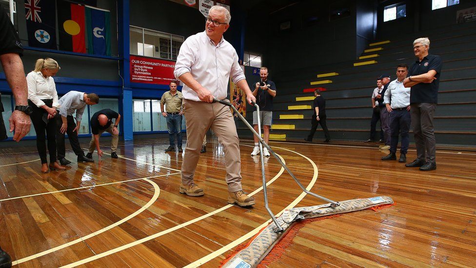 Scott Morrison mops up a basketball court in a photo opportunity that was criticised as appearing staged