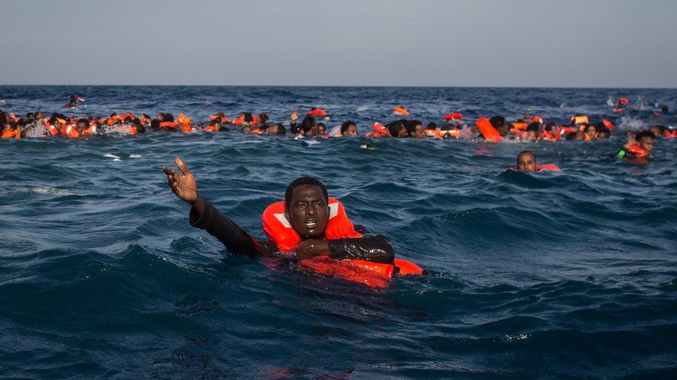 Refugees and migrants are seen swimming and yelling for assistance from crew members from the Migrant Offshore Aid Station (MOAS) 'Phoenix' vessel after a wooden boat bound for Italy carrying more than 500 people capsized on May 24, 2017 off Lampedusa