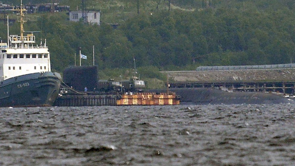 A rescue tugboat (L) and the BS-136 Orenburg ballistic missile submarine (R) carrying a nuclear deepwater station of Project 10831 at the Russian Northern Fleet's base