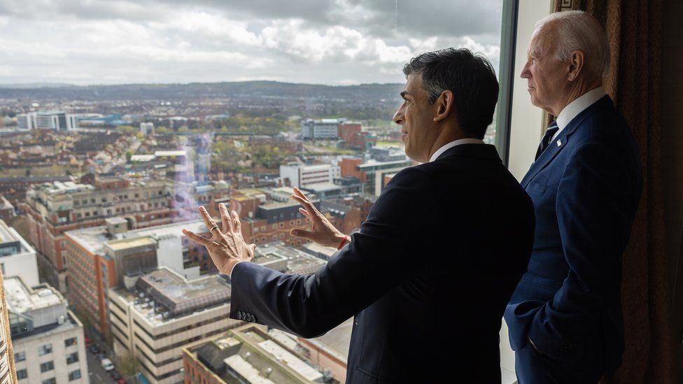 Rishi Sunak and Joe Biden look at the view over Belfast from the 23rd floor of the Grand Central Hotel