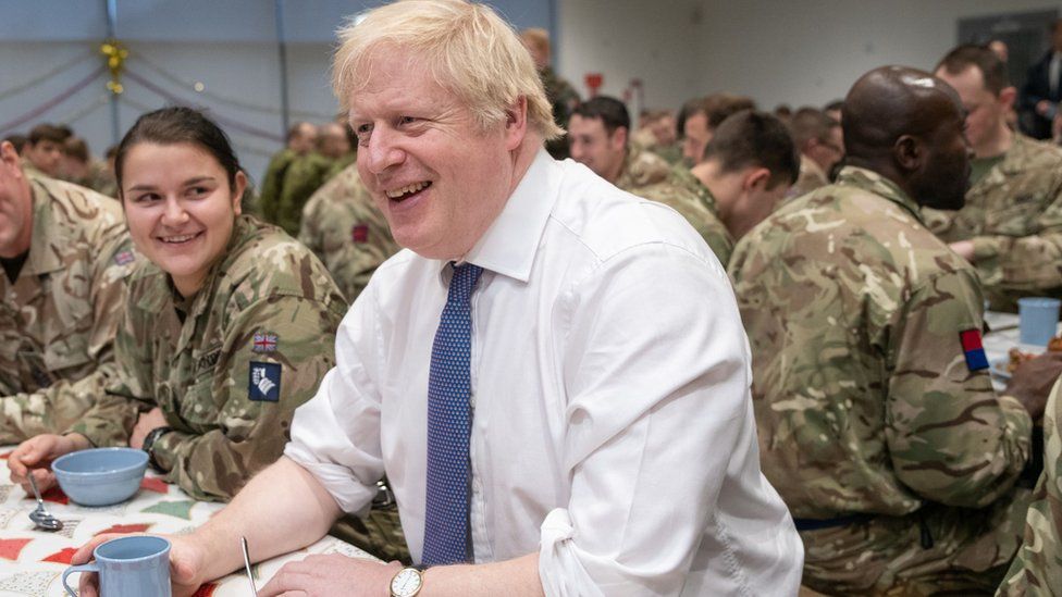 Britain"s Prime Minister Boris Johnson meets British troops stationed in Estonia for a meal at the Tapa military base