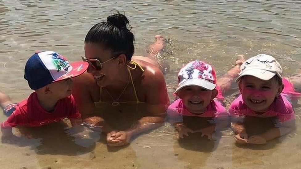 Hannah Clarke and her three children lie on a beach