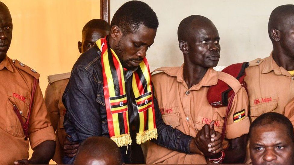Uganda's prominent opposition politician Robert Kyagulanyi known as Bobi Wine (C) appears at the chief magistrate court in Gulu, northern Uganda, on August 23, 2018