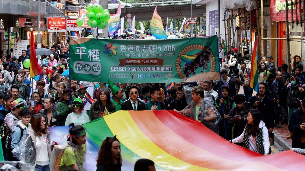 Participants of Hong Kong's annual pride parade walk through the streets with a large rainbow flag on November 26, 2016