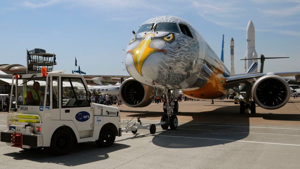 A truck pulls an Embraer E195-E2 towards the runway at the tarmac at the International Paris Air Show in Le Bourget outside Paris on June 20, 2017
