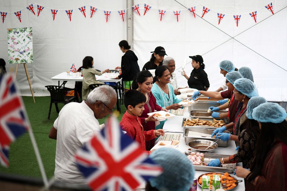 People are served food at a 'Big Lunch' event at the BAPS Shri Swaminarayan Mandir temple during celebrations following the coronation of King Charles and Queen Camillla, in London, Britain May 7, 2023