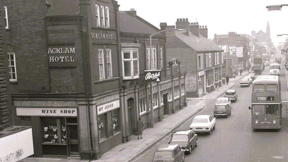 Black and white photograph of the Acklam Hotel and traffic driving past