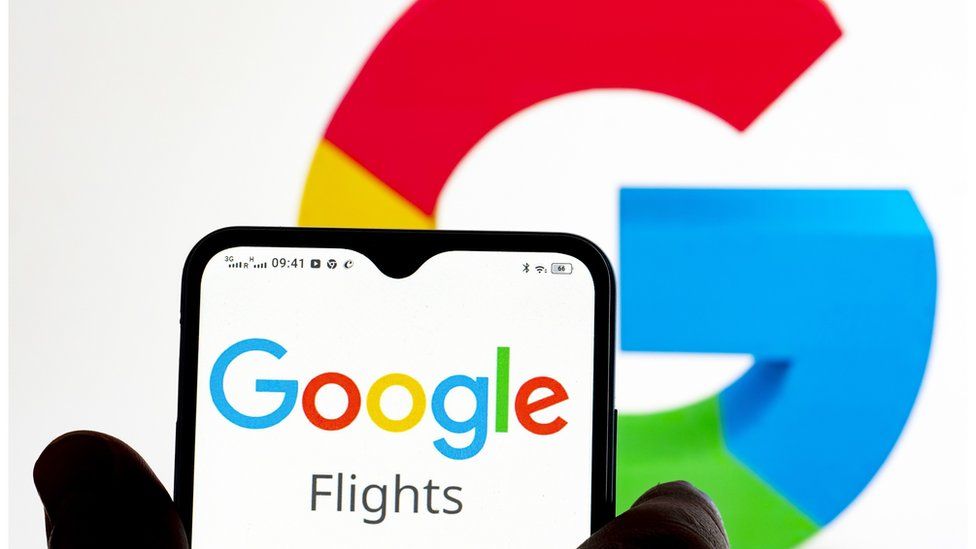 Person holds a phone with the Google flights app above the google sign
