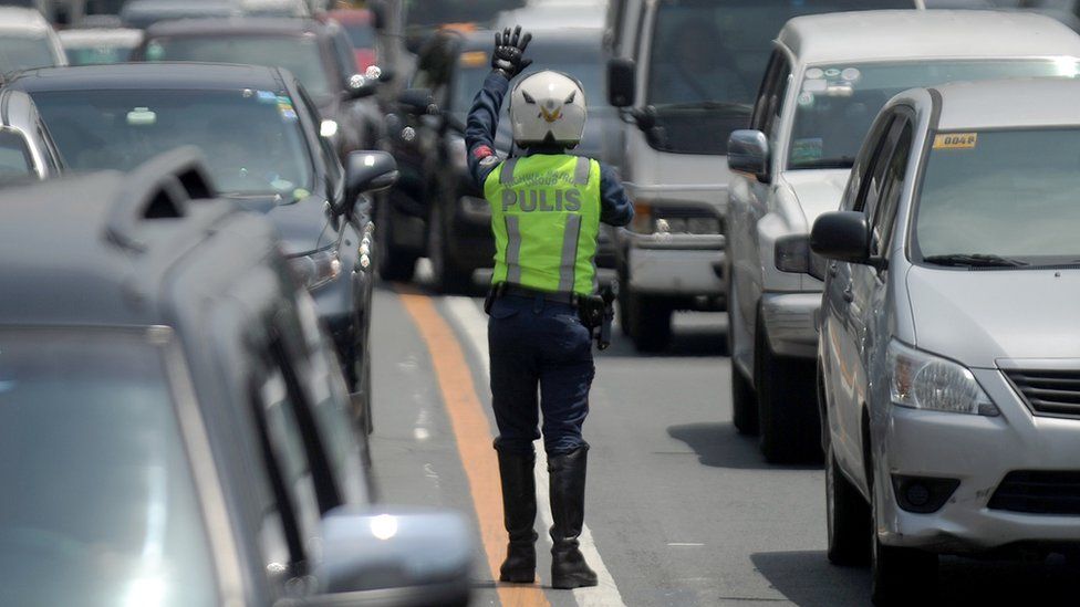A police officer directs traffic in Manila