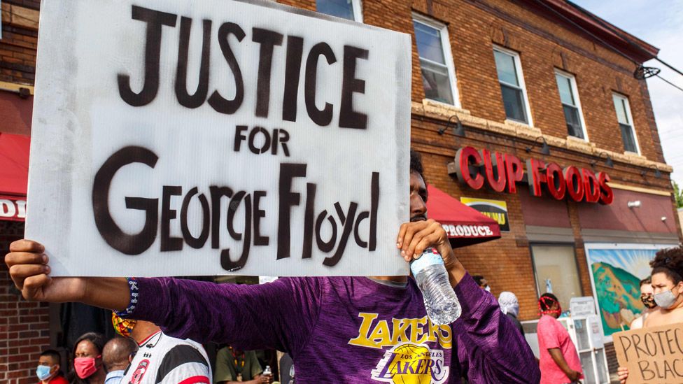 Protester holding up a sign saying "Justice for George Floyd"
