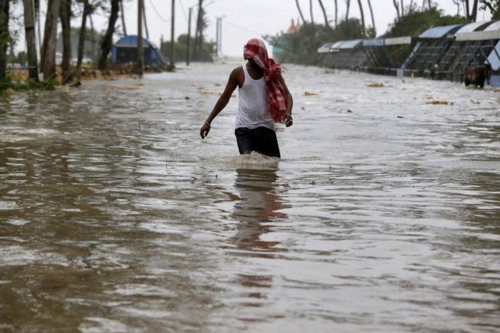 A man wades through a water-logged road after rains ahead of Cyclone Yaas at Digha in Purba Medinipur district in the eastern state of West Bengal, India, May 26, 2021