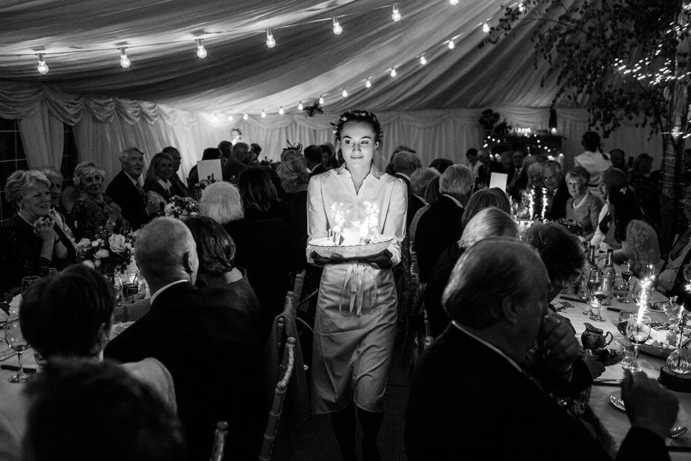 A waitress carries food through a wedding reception