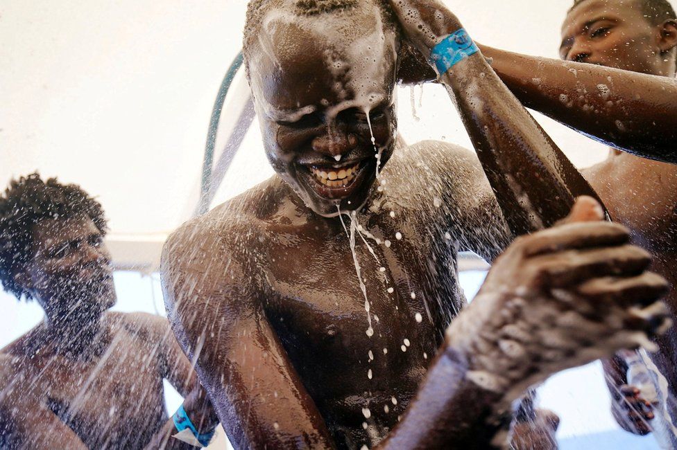 Chuol, 17, from Sudan, takes shower on board Spanish NGO Proactiva Open Arms rescue boat