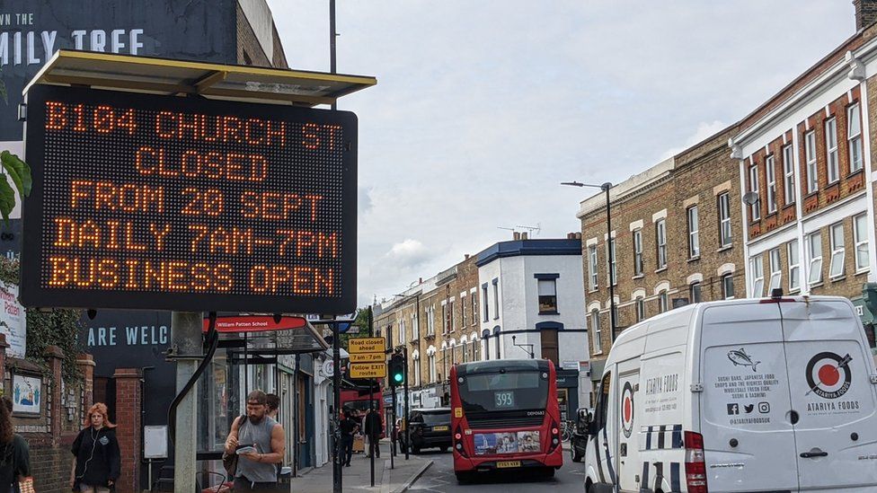 Illuminated traffic sign and street signage about traffic restrictions on Church Road in the borough of Hackney.