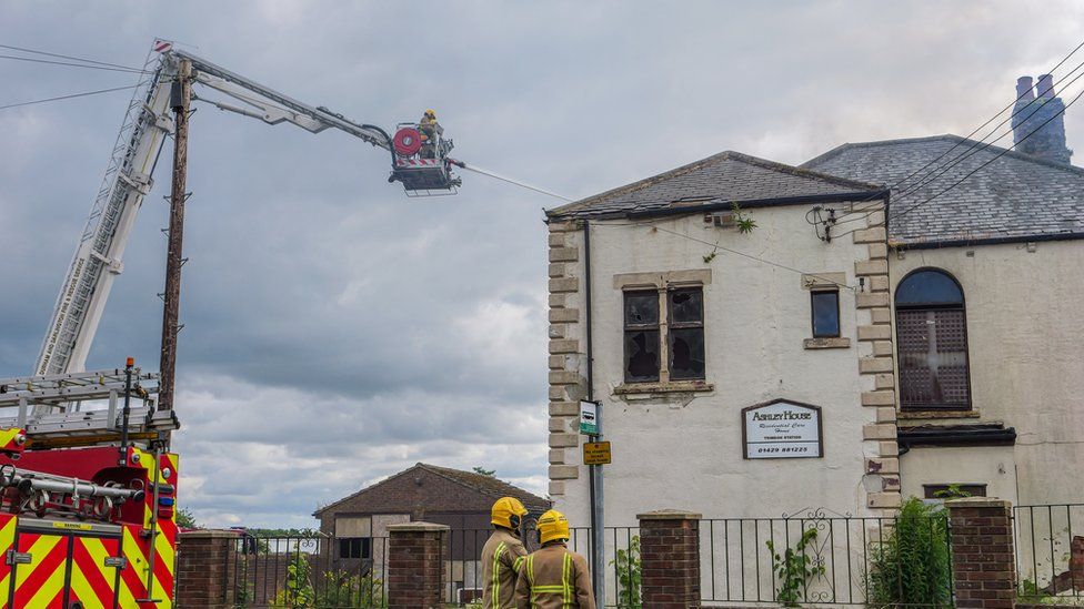 Firefighters using aerial ladder and jet