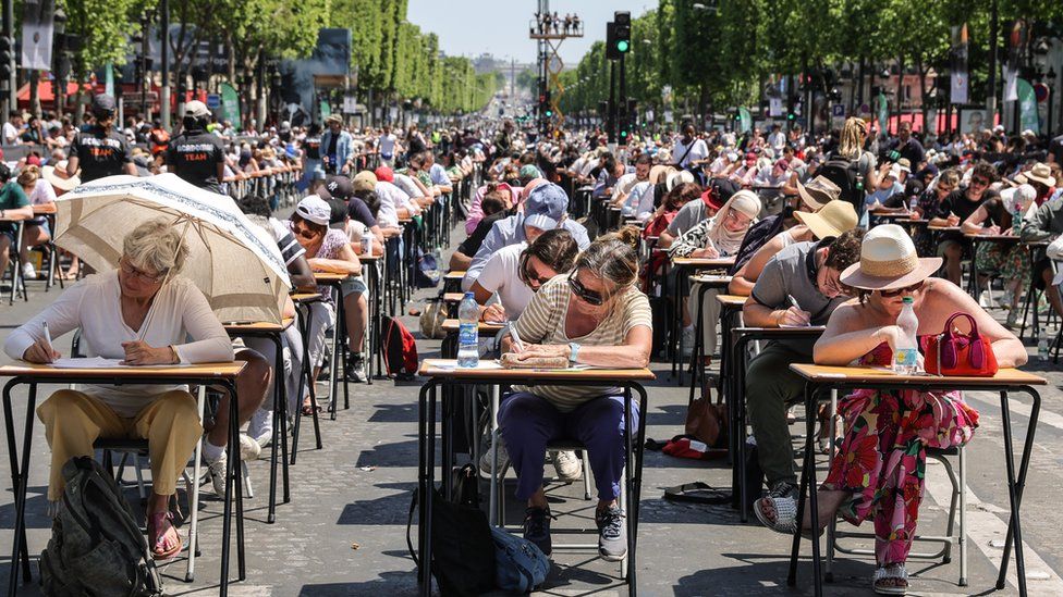 Participants pay attention and write during 'The World's Biggest Dictation' on the Champs Elysees in Paris, France, 04 June 2023. The Champs-Elysees Committee, organizers of the event, expect around 1,700 participants to take part in the challenge, an attempt to validate the Guinness Book World Record for the world's largest spelling test.