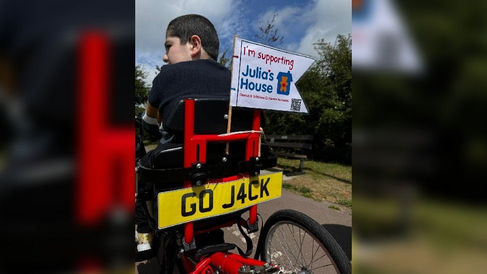 Red tricycle with a custom numberplate, which reads GO J4CK