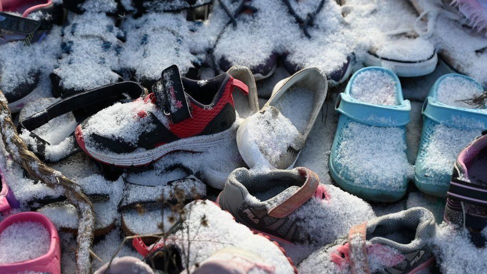 Children's shoes adorn a memorial for Saint-Marc-de-Figuery residential school student at the site of the former school near Amos, Canada, November 17, 2021