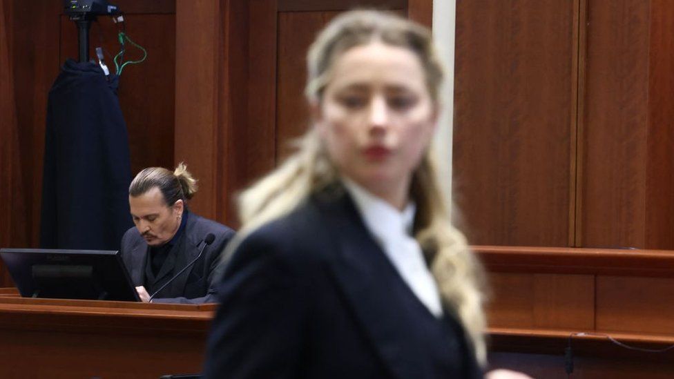 US actress Amber Heard (R) speaks to her legal team as US actor Johhny Depp (L) returns to the stand after a lunch recess during the 50 million US dollar Depp vs Heard defamation trial at the Fairfax County Circuit Court in Fairfax, Virginia, April 21, 2022