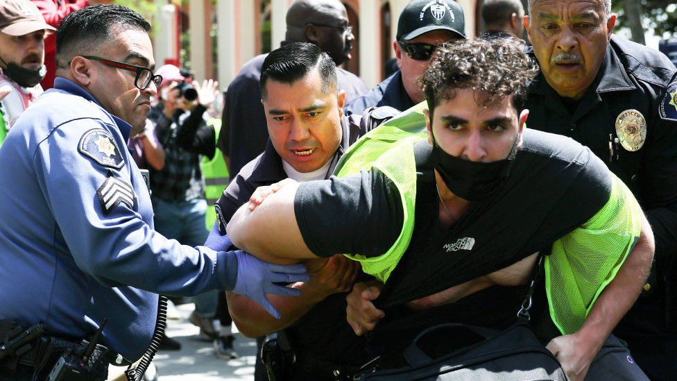 USC public safety officers detain a pro-Palestine demonstrator during clashes after officers attempted to take down an encampment in support of Gaza at the University of Southern California on April 24, 2024 in Los Angeles