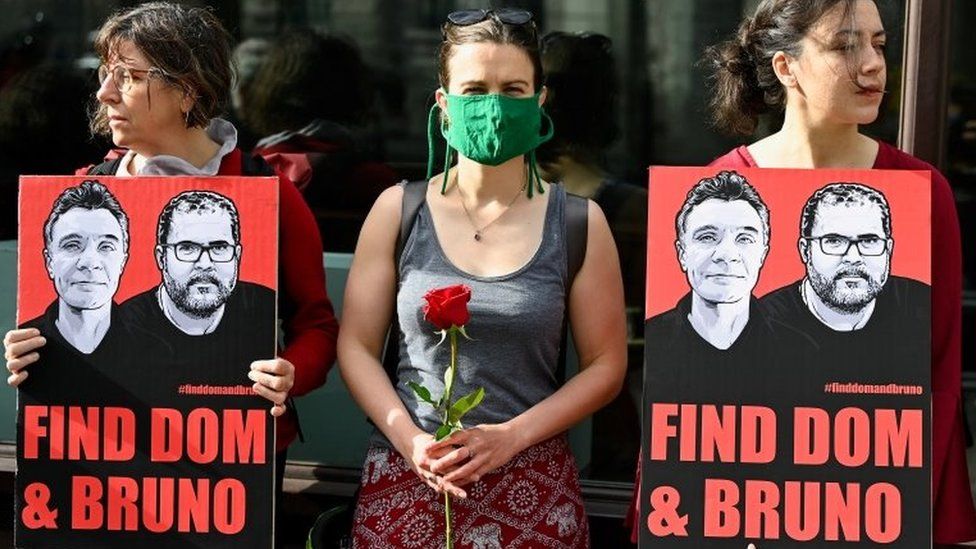 Демонстранты держат плакаты и розы в знак протеста против исчезновения в Амазонии журналиста Дома Филлипса и участника кампании Бруно Араужо Перейры возле посольства Бразилии в Лондоне, Великобритания, 9 июня 2022 года.