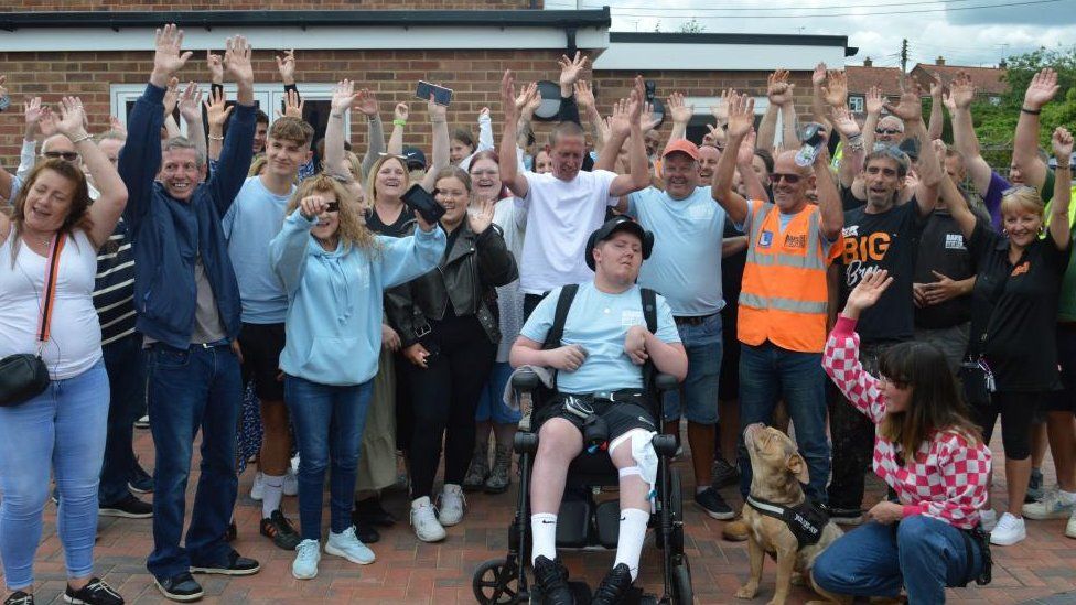 Family, friends and volunteering celebrating with Luke Goold-Hannatt following the completion of the extension at his family home