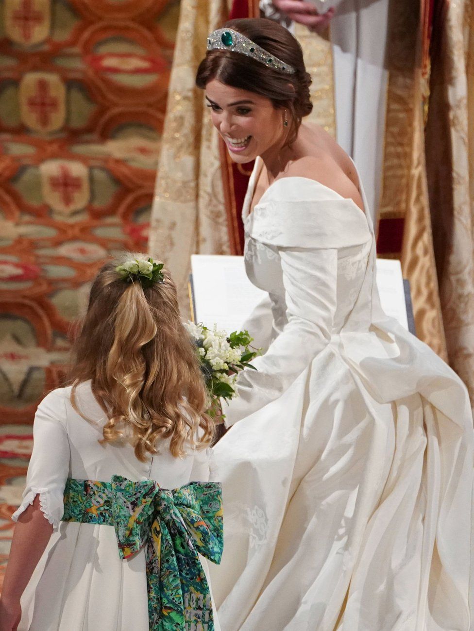 Princess Eugenie of York passes her bouquet to bridesmaid