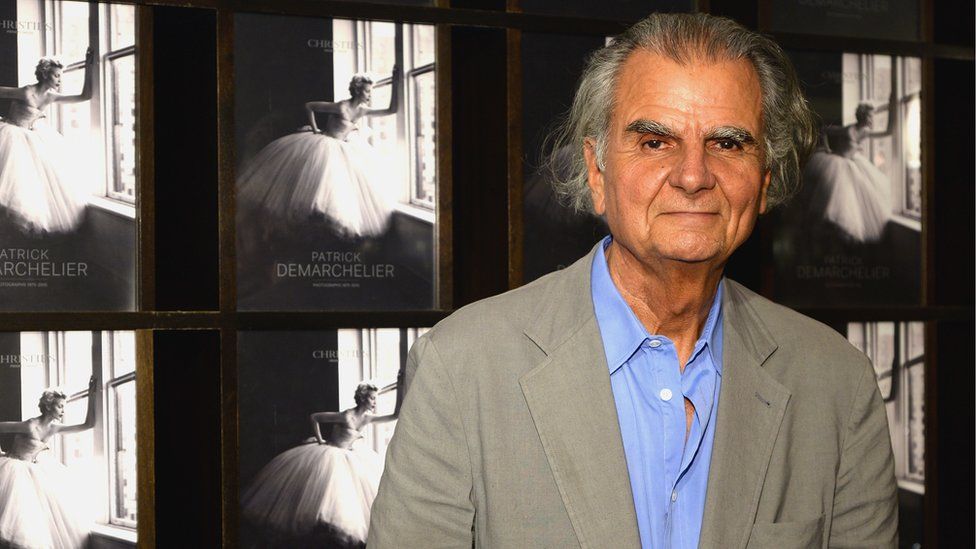 Patrick Demarchelier in front of some of his photos