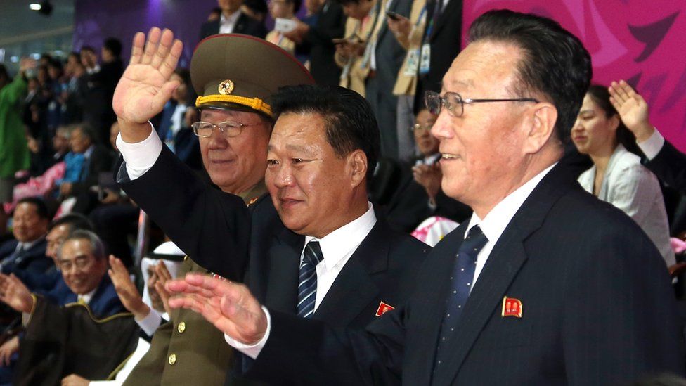 Hwang Pyong-so (L), Choe Ryong-hae (C) and Kim Yang-gon waving hands at Asian Games in Incheon in 2014