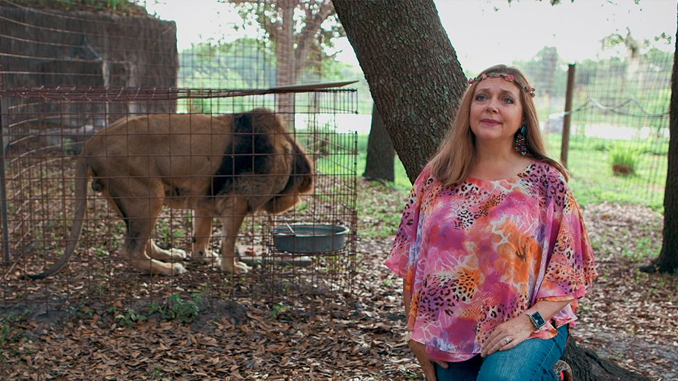Carole Baskin and a lion in a cage