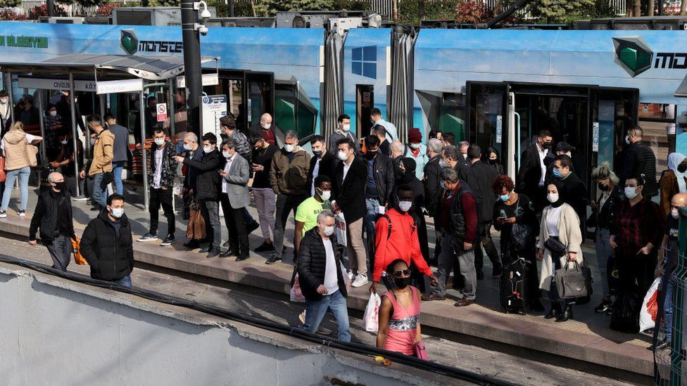People wait in a queue at Cevizlibag district to get on metrobuses and trams to return their homes on 29 April
