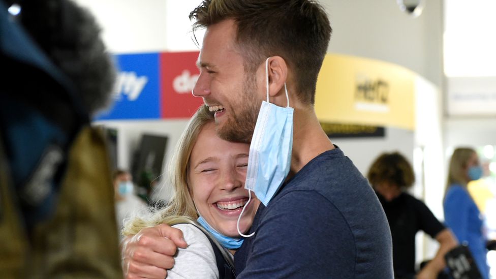 A couple reunites at Gold Coast airport after Queensland lifts a five-month border closure