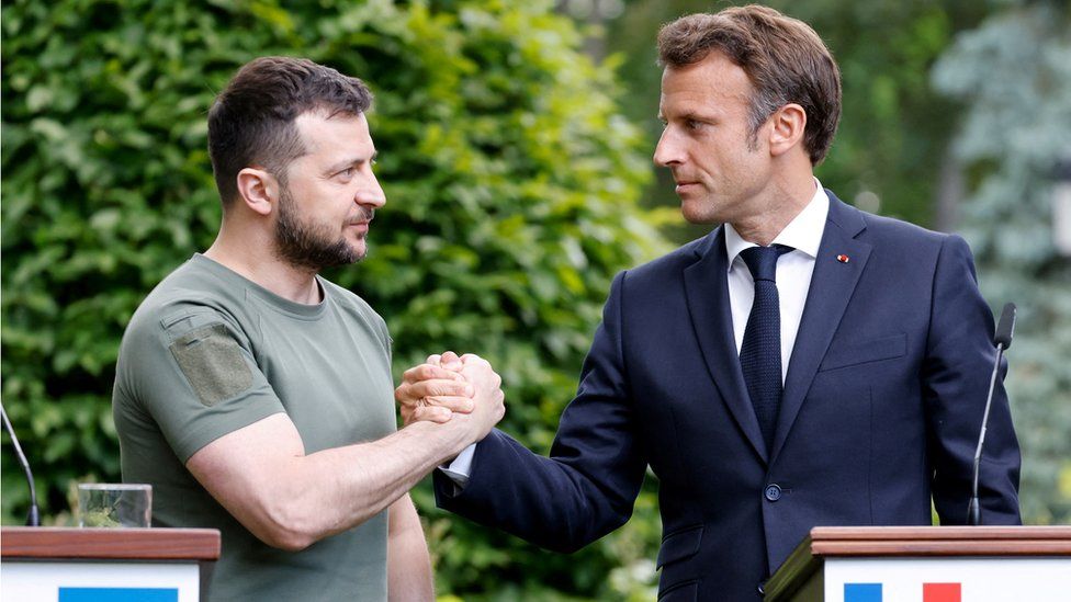 Ukrainian President Volodymyr Zelensky and French President Emmanuel Macron shake hands after giving a news conference in Kyiv on 16 June