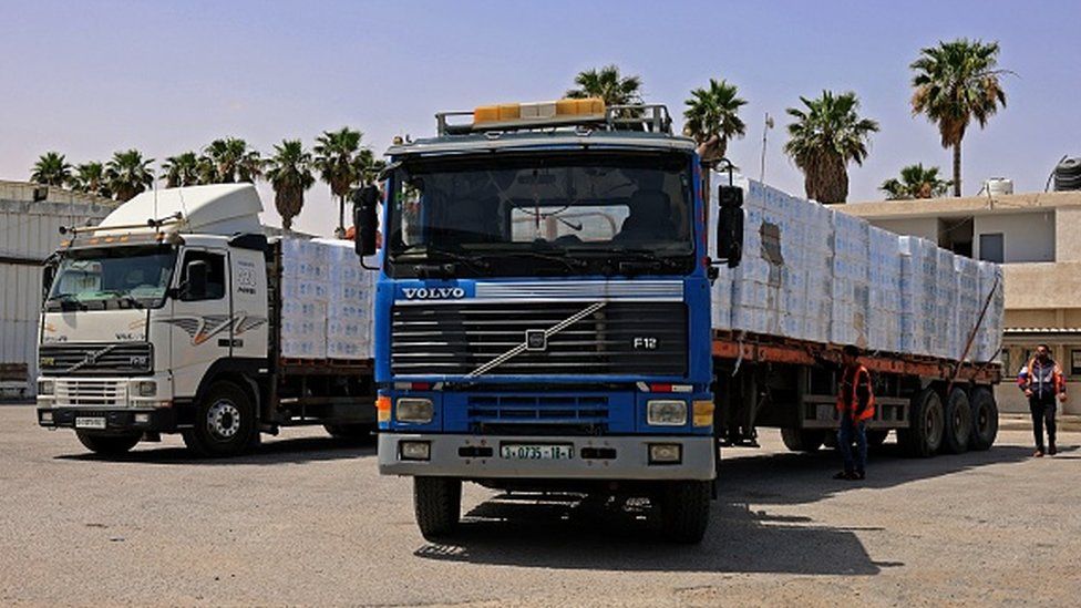Trucks loaded with humanitarian aid pass into the Gaza Strip through the Kerem Shalom crossing