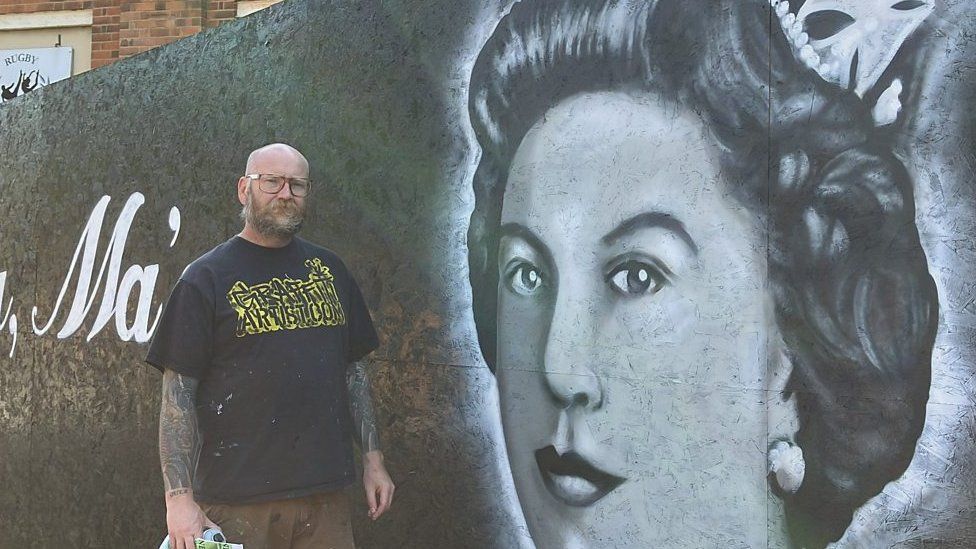 Artist David Brown in front of mural